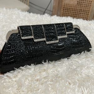 NWT Unique black leather clutch. Beautiful back, snaps shut.